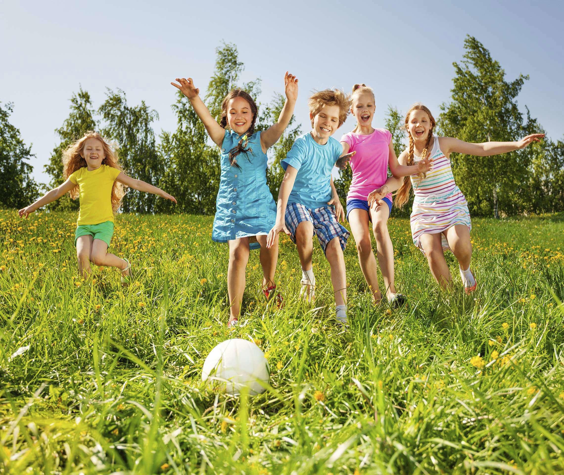 Kinder spielen mit Fußball