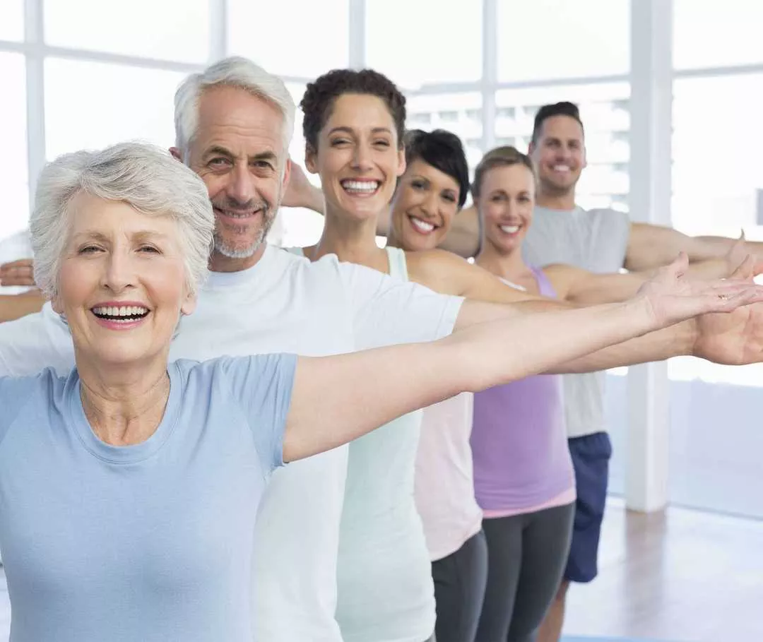 Personengruppe lächelt beim Sport in die Kamera