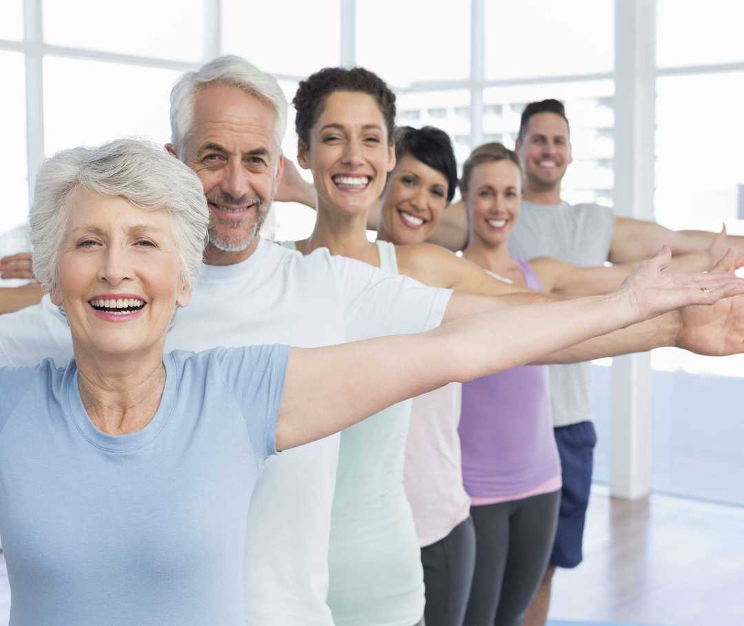 Personengruppe lächelt beim Sport in die Kamera