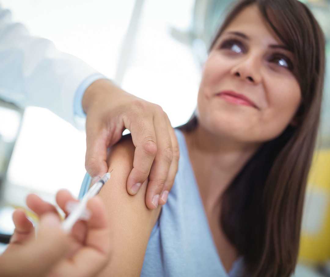 Junge Frau wird von ihrem Arzt geimpft