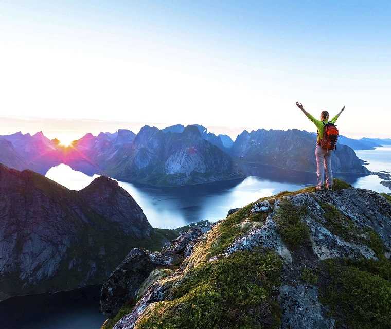 Person auf Berg jubelt ins Tal