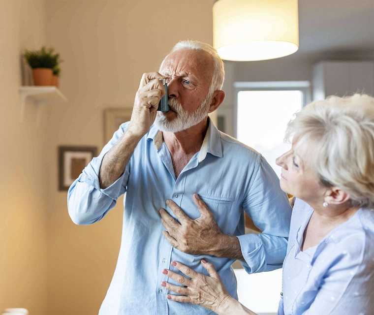 Älterer Mann benutze Asthmaspray