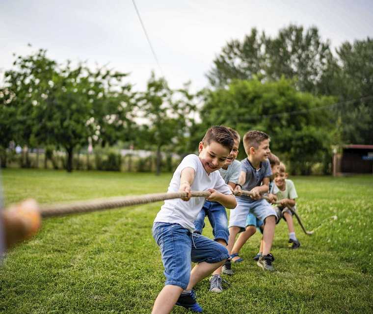 Kinder spielen Tau ziehen