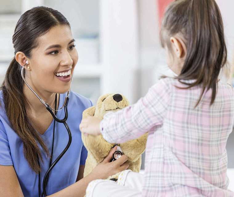 Ärztin untersucht Teddy eines Mädchens