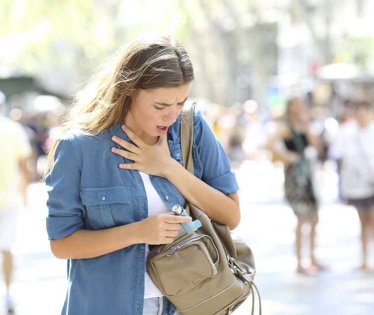 Frau sucht Asthmaspray aus der Tasche