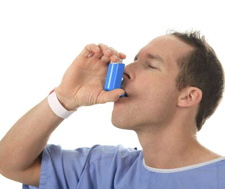 Mann benutzt Asthmaspray Mann benutzt Asthmaspray