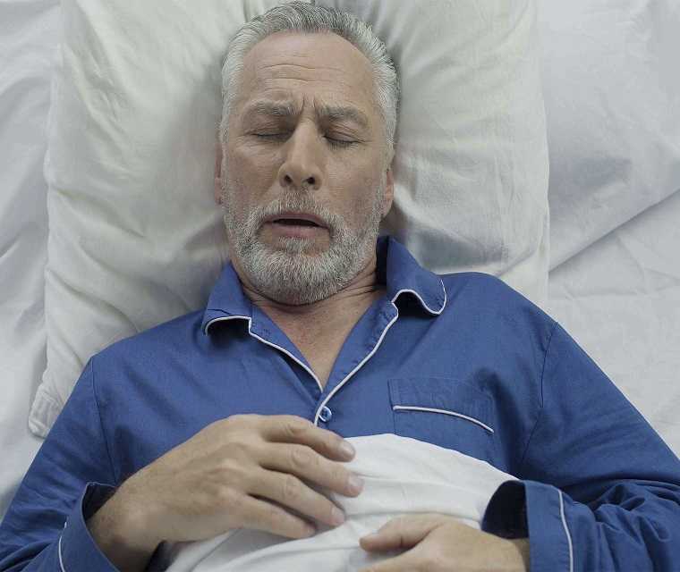 Mann hat Atemnot im Bett