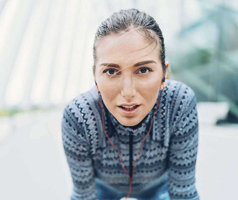 Frau atmet nach dem Joggen durch